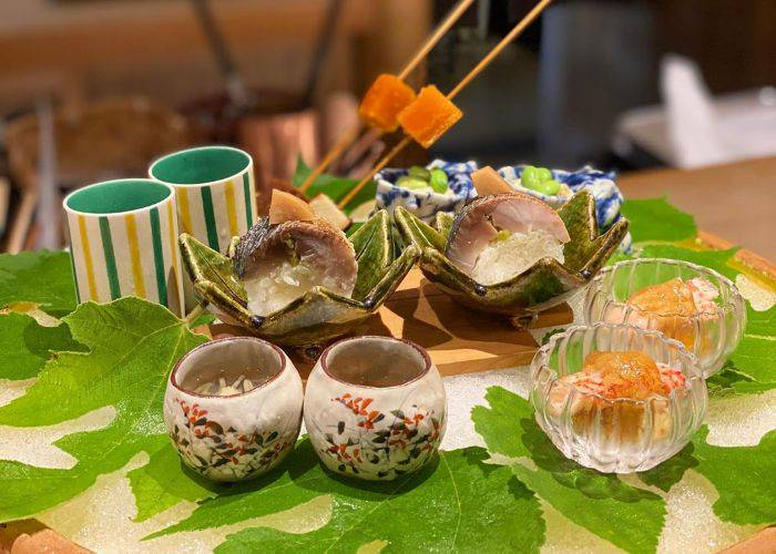 A memorable serving of dishes at Gion Nishikawa, laid out on a leaf-decorated platter.